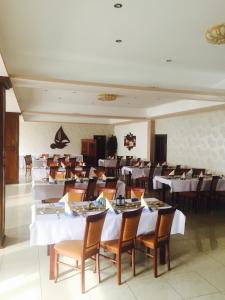 a dining room with white tables and chairs at Penzión Anima in Kaluža