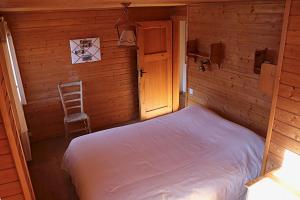 a small bedroom with a bed and a chair at Magnifique chalet pour 10 personnes à Vercorin in Vercorin