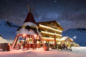 a snow covered ski resort with a ski lift on top of it at Hotel Alpina in Fiesch