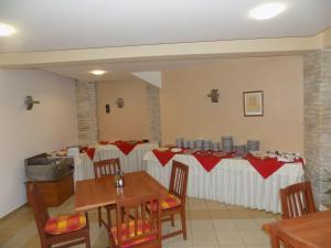 a dining room with tables with red and white tablecloths at Sirena Hotel in Kranevo