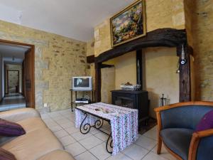 a living room with a table and a stove at Heavenly holiday home with pool in Villefranche-du-Périgord