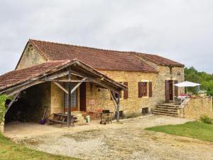 a large brick building with a table and an umbrella at Heavenly holiday home with pool in Villefranche-du-Périgord