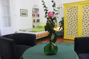 eine Vase mit einer Rose auf einem Tisch im Wohnzimmer in der Unterkunft Apartment NiNi in Wien