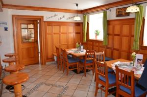 a dining room with wooden tables and chairs at Hotel-Restaurant Kirchenwirt Aigen in Aigen im Ennstal