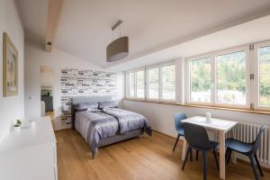 ein Schlafzimmer mit einem Bett und einem Tisch und Stühlen in der Unterkunft Moderne Apartments in attraktivem Altbau in Freiburg im Breisgau