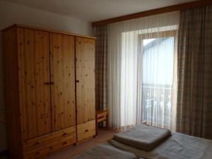 1 dormitorio con un gran armario de madera y una ventana en Ferienwohnung Maag, en Lechbruck