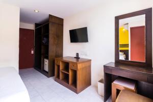a room with a mirror and a dresser and a television at 18 Coins Budget Hotel in Pattaya Central