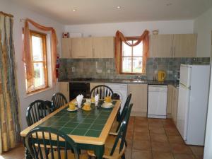 een keuken met een tafel en stoelen en een keuken met een tafel en een keuken bij Achill Sound Holiday Village in Achill Sound