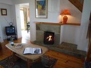 a living room with a fireplace and a table at Achill Sound Holiday Village in Achill Sound