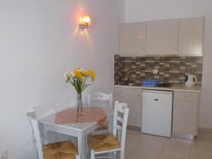a kitchen with a table with a vase of flowers on it at Hotel Agnadi in Amorgos +53 photos