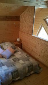1 dormitorio con 1 cama en una cabaña de madera en La cabane du pommier, en Orelle