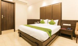 a bedroom with a large bed with a wooden headboard at Treebo Bliss in Jaipur