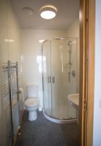 a bathroom with a shower and a toilet and a sink at By The Bay in Cruden Bay