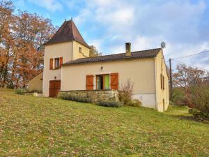 a small white house on a grassy hill at Holiday home with private garden in Cazals