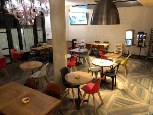 un restaurante vacío con mesas y sillas y una lámpara de araña en Ibis Budget Annecy sud-Poisy en Poisy