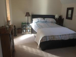 a bedroom with a bed and a dresser at Cowes - The Barn in Cowes