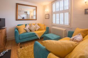 a living room with two couches and a mirror at Pugwash in Aldeburgh