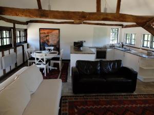 泰晤的住宿－The Thatched Barn，一间带黑色沙发的客厅和一间厨房