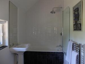 泰晤的住宿－The Thatched Barn，带浴缸、水槽和淋浴的浴室