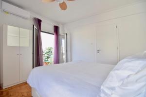 a white bedroom with a large bed and a window at Athens central apartment with Acropolis views! - SQ1 in Athens