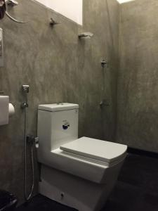 ein Badezimmer mit einem weißen WC und einer Dusche in der Unterkunft US Motel Colombo in Homagama