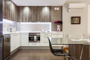 a kitchen with white cabinets and a glass table at 1324 - OLYMPIC DELUXE in Barcelona