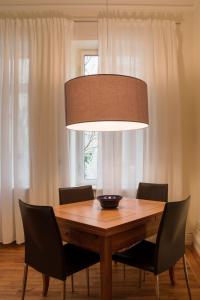 a dining room table with chairs and a large light fixture at Zweite Heimat Heidelberg in Heidelberg