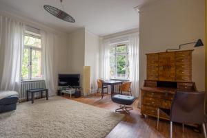 ein Wohnzimmer mit einer Holzkommode und einem Schreibtisch in der Unterkunft Zweite Heimat Heidelberg in Heidelberg