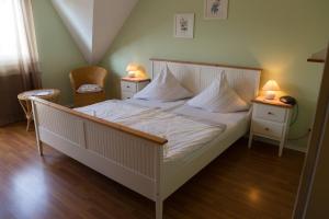 ein Schlafzimmer mit einem weißen Bett und zwei Nachttischen in der Unterkunft Hotel Reichsschenke Zum Ritter Götz "Garni" in Kröv