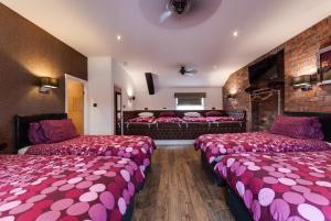 um quarto de hotel com duas camas com lençóis cor-de-rosa em Tom Thumb Apartments em Liverpool