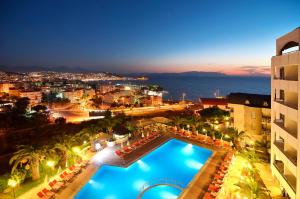 a view of a city at night with a swimming pool at City's Hill Hotel in Kuşadası