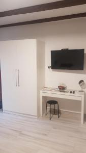 a white room with a desk and a tv on a wall at Home Away From Home - Apartment Ilica in Zagreb