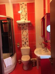 a bathroom with a toilet a sink and a mirror at Zava Boutique Hotel Central in Bucharest