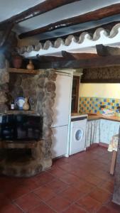eine Küche mit einem weißen Kühlschrank und einem Herd in der Unterkunft El Nido in Zahara de la Sierra