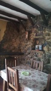a dining room with a table and chairs and a stone wall at El Nido in Zahara de la Sierra +22 photos