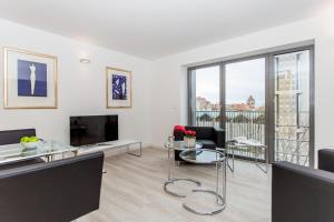 a living room with a table and chairs and a tv at MAVO Hospitality Stuttgart Bismarckstrasse in Stuttgart