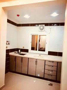 نيو هوم للوحدات السكنية  في ينبع: حمام مع حوض ومرآة