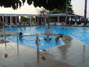 a group of people in a swimming pool at Villa Eugenia in Theologos