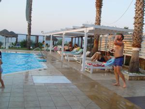 un grupo de personas sentadas alrededor de una piscina en un complejo en Villa Eugenia, en Theológos