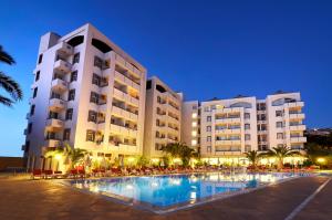 a hotel with a swimming pool in front of a building at City's Hill Hotel in Kuşadası