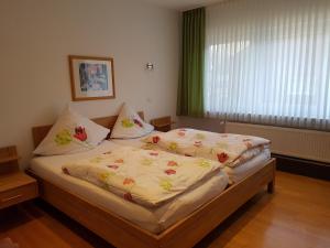a bedroom with a bed with a yellow comforter on it at Hotel Pension Haus Pooth in Wesel