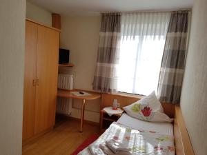 Habitación pequeña con cama y ventana en Hotel Pension Haus Pooth, en Wesel