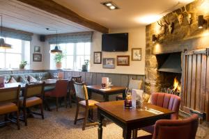a restaurant with tables and chairs and a fireplace at The Kestrel by Innkeeper's Collection in Harrogate