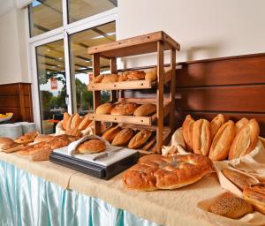a table topped with lots of different types of bread at City's Hill Hotel in Kuşadası