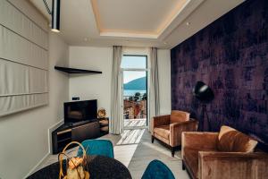 a living room with a couch and chairs and a television at Apartments Master 5 in Herceg-Novi
