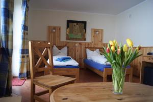 una habitación con 2 camas y una mesa con un jarrón de flores en Panorama Lake Resort en Nowe Guty