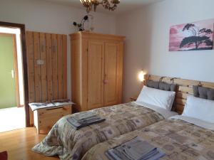 a bedroom with a large bed and a wooden cabinet at Casa Noemi Imer in Imer