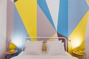 1 dormitorio con 1 cama con una pared colorida en First Hostel en Bucarest