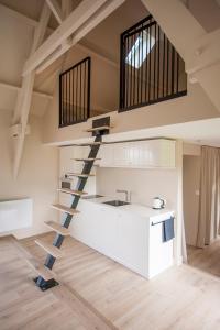 une cuisine avec un escalier en colimaçon dans un loft dans l'établissement Le Pave de la Croix Blanche, à Le Pavé