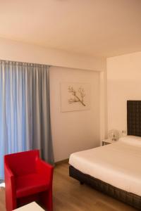 a bedroom with a bed and a red chair at Park Hotel Residence in Crema